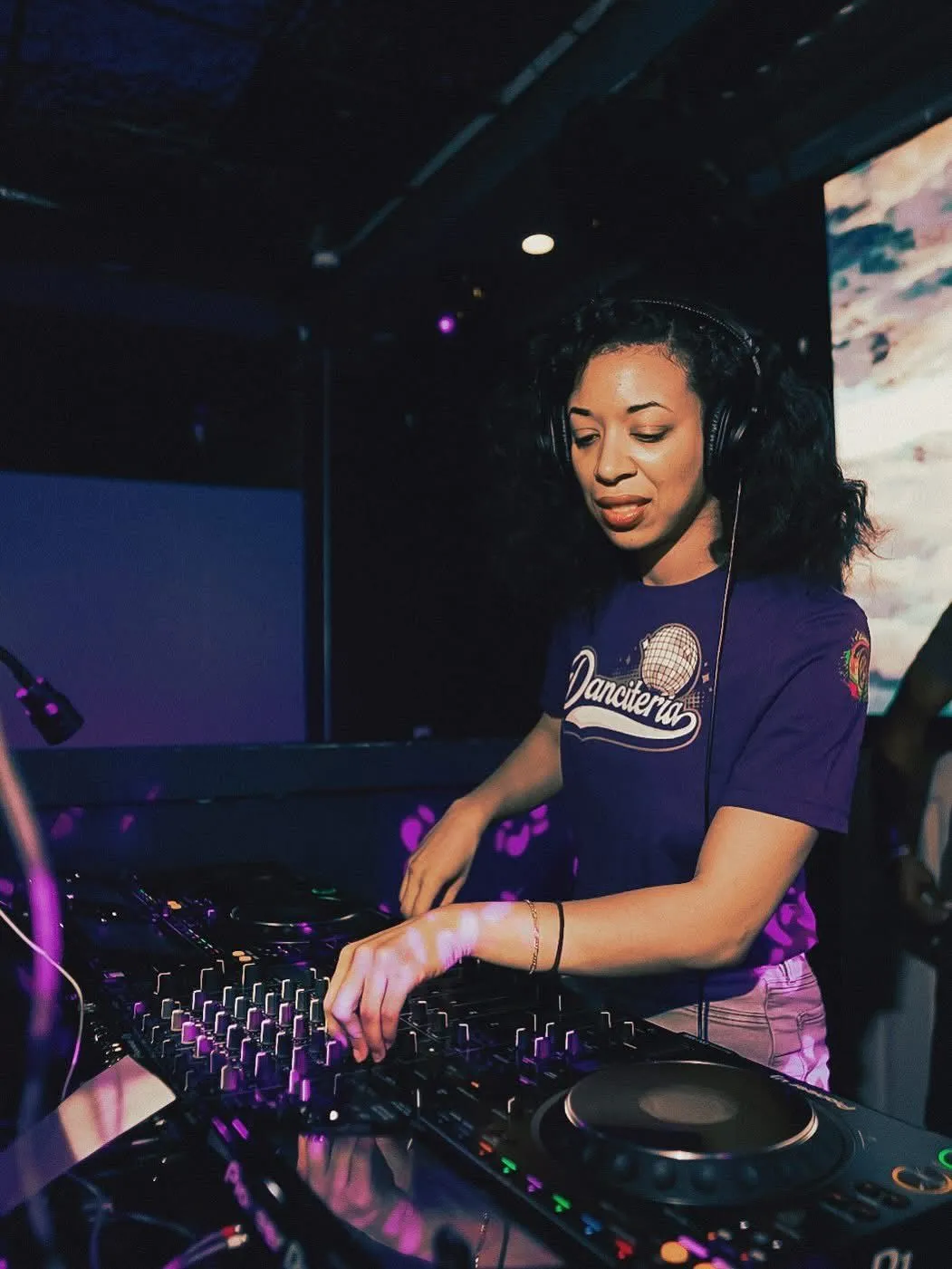 D Lo performing as an Ember behind a DJ console at a Danceteria event