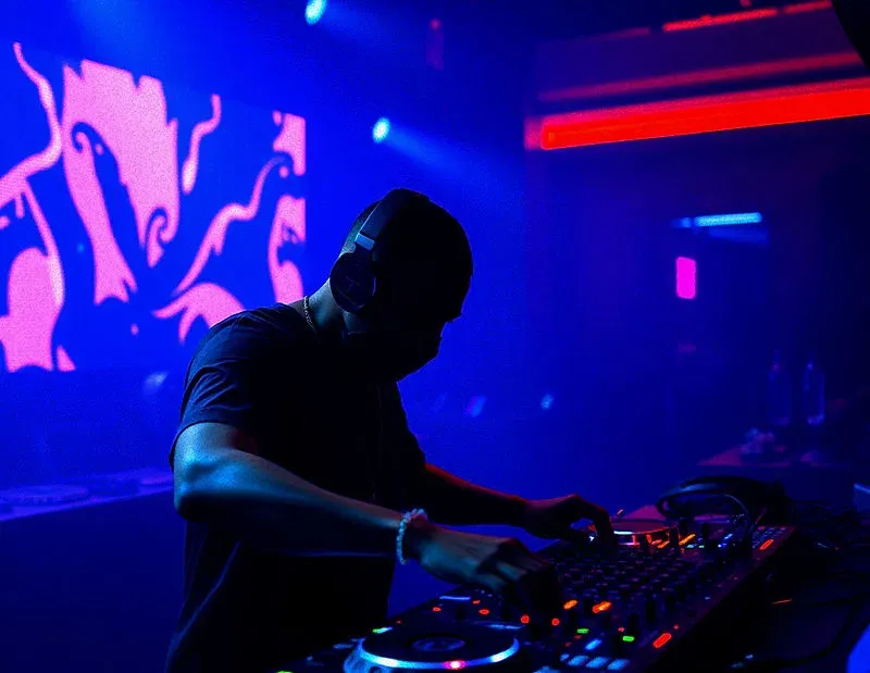DJ performing under neon club lights